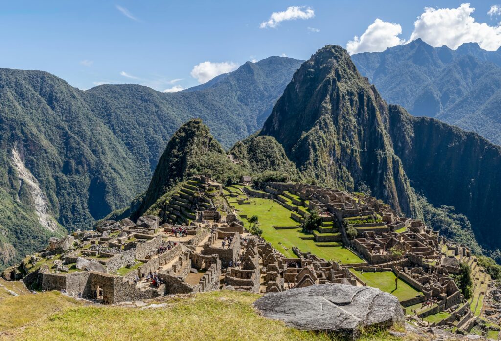 Aerial view of the iconic Machu Picchu ruins surrounded by lush green mountains in Peru.